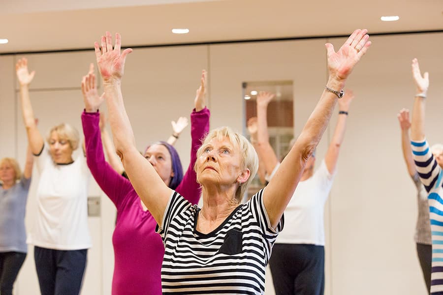 Seniorinnen beim Fitnesskurs, Arme gehoben