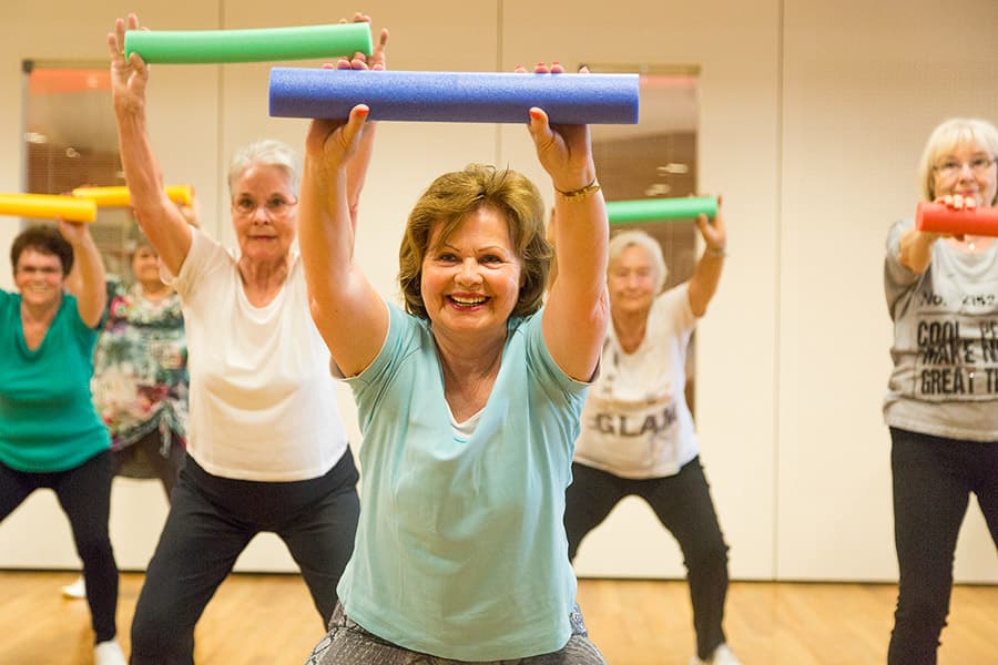 Senioren-Fitness mit Gymnastikstäben in der Gruppe.