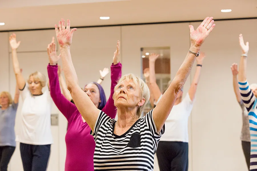 Seniorinnen beim Fitnesskurs, Arme gehoben