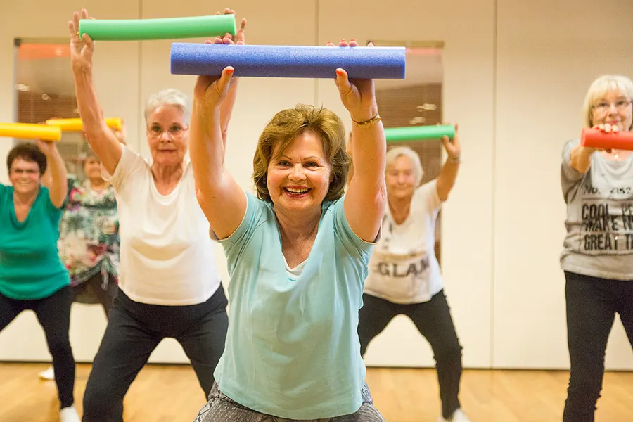 Senioren-Fitness mit Gymnastikstäben in der Gruppe.